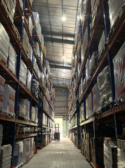 Filming inside a large warehouse with neatly organized goods